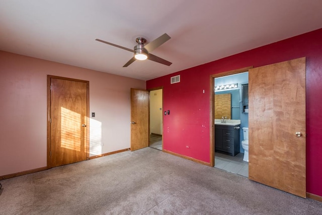 unfurnished bedroom featuring ceiling fan, light colored carpet, sink, and connected bathroom