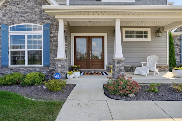 entrance to property with a porch and french doors