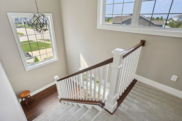 staircase with a notable chandelier