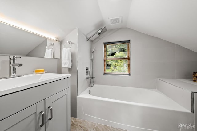 bathroom featuring vanity, a tub, and lofted ceiling