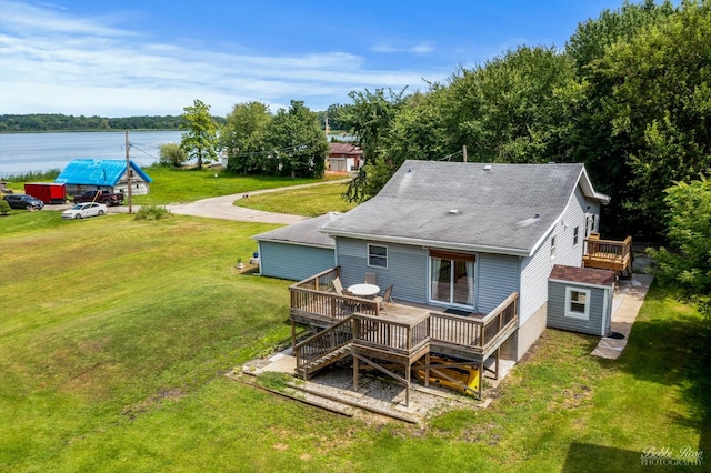 rear view of house featuring a lawn and a deck with water view