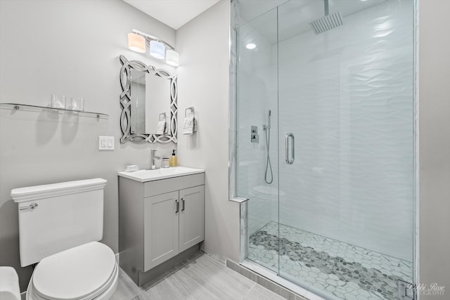 bathroom featuring tile patterned floors, vanity, toilet, and an enclosed shower