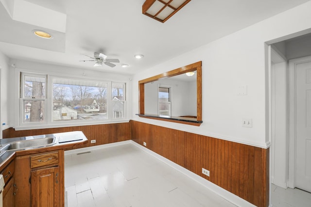 interior space with ceiling fan and wooden walls