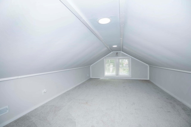 bonus room featuring vaulted ceiling and light colored carpet