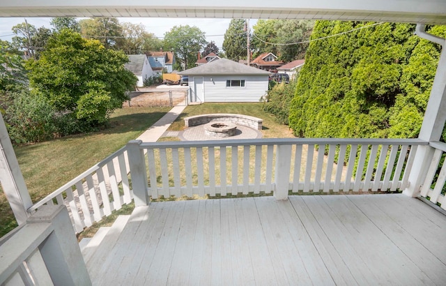 deck featuring a storage shed, a yard, and an outdoor fire pit