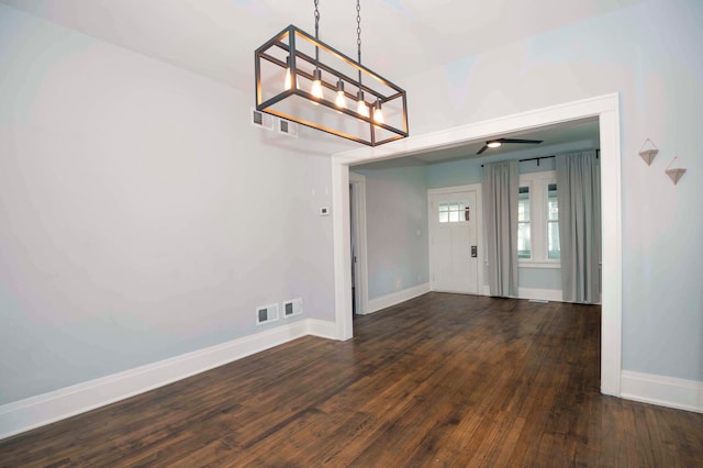 unfurnished dining area with ceiling fan and dark hardwood / wood-style floors