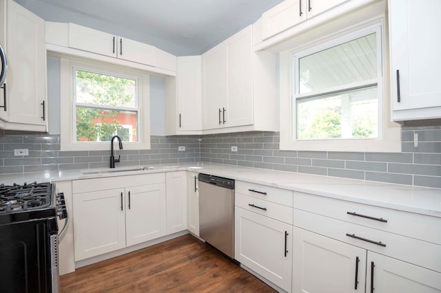 kitchen featuring stainless steel dishwasher, dark hardwood / wood-style flooring, tasteful backsplash, and white cabinets