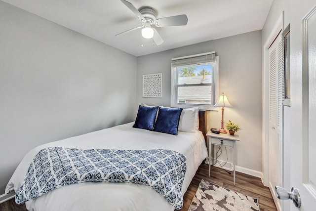 bedroom featuring dark wood-type flooring, a closet, and ceiling fan