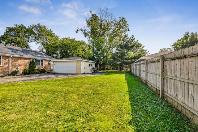 view of yard featuring a garage and an outbuilding