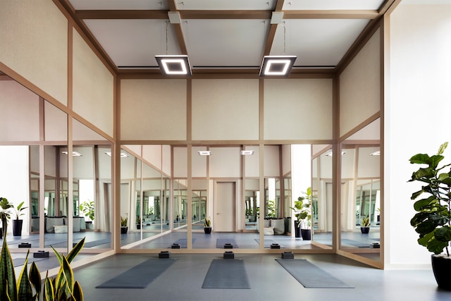 workout area with a high ceiling and a wall of windows