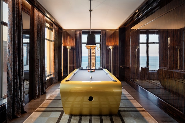 game room featuring a water view, hardwood / wood-style floors, and billiards