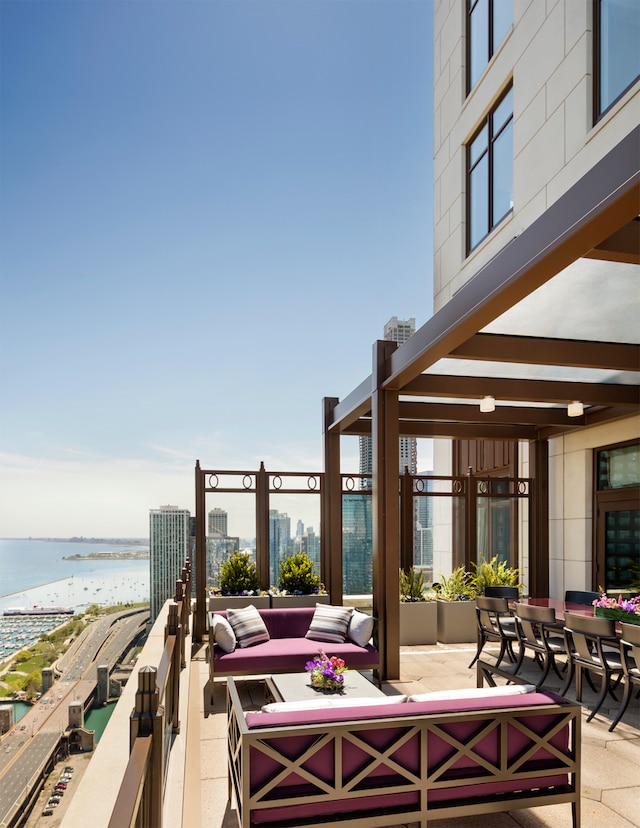 view of patio / terrace with a water view, outdoor lounge area, and a beach view