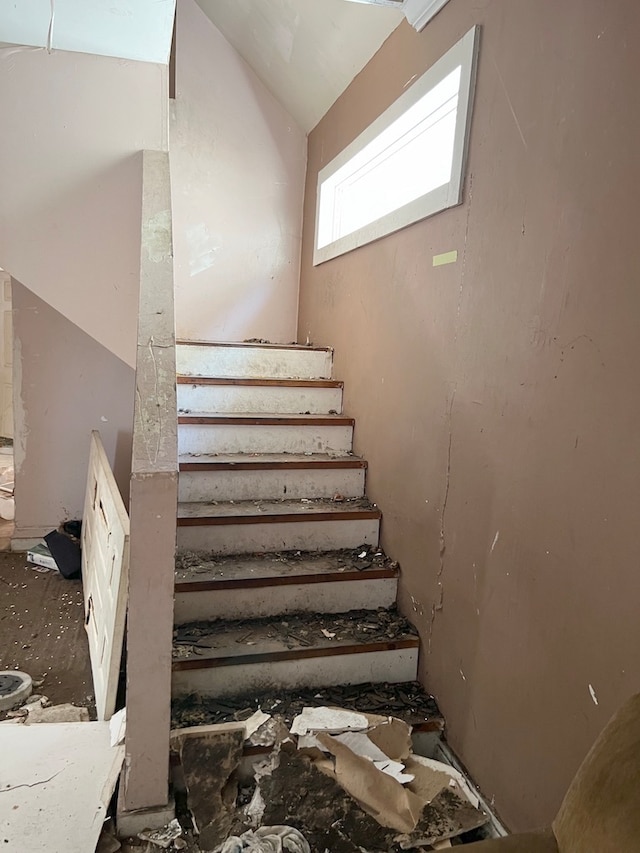 stairway featuring lofted ceiling