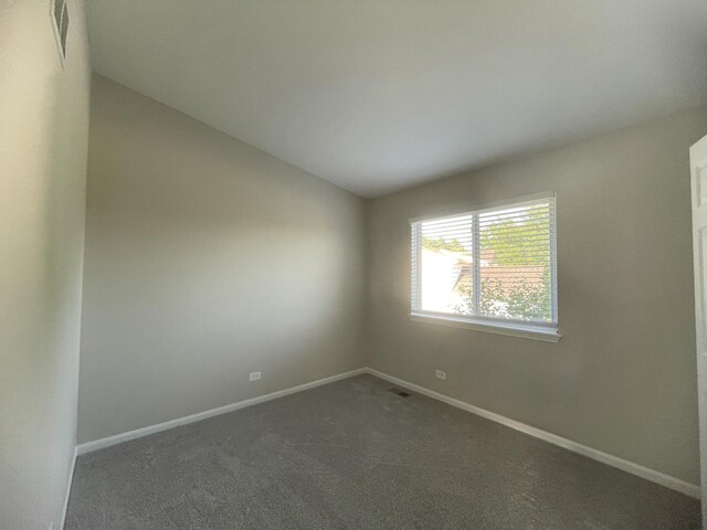 carpeted spare room featuring lofted ceiling