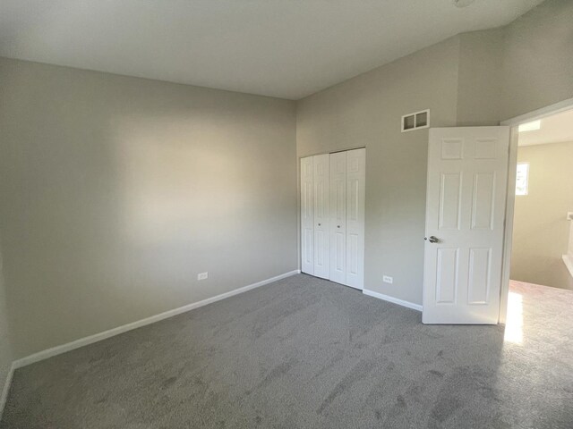 unfurnished bedroom with dark carpet and a closet