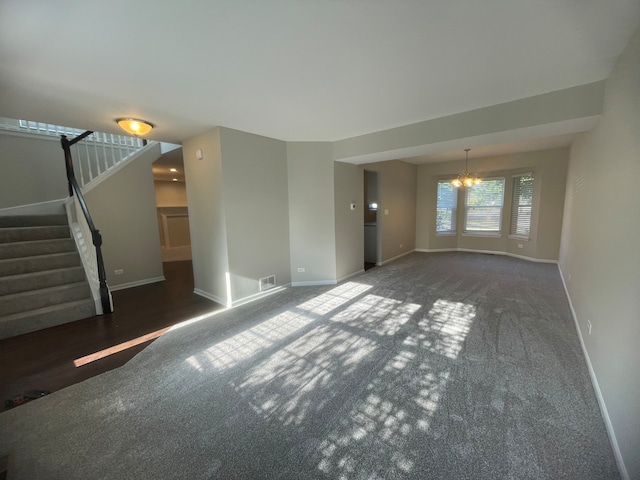 unfurnished room with dark carpet and a notable chandelier