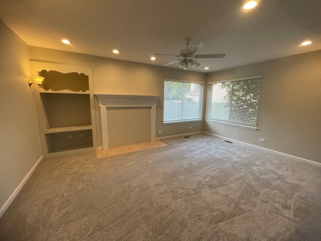 unfurnished bedroom featuring a fireplace, ceiling fan, and carpet floors