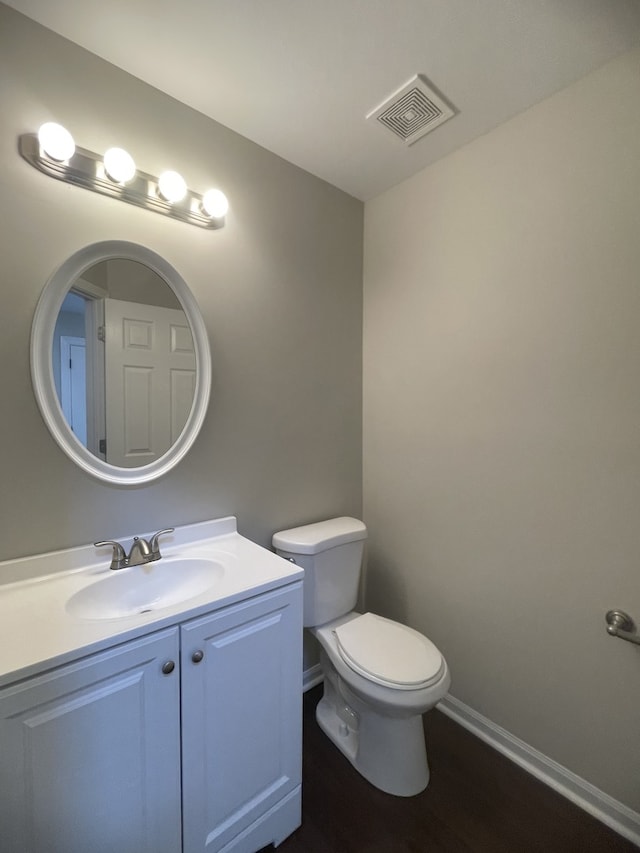 bathroom with vanity, toilet, and hardwood / wood-style floors