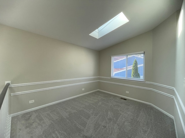 empty room with carpet and lofted ceiling with skylight