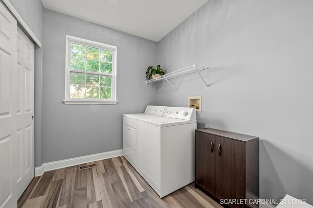 laundry area featuring light hardwood / wood-style floors and washing machine and clothes dryer