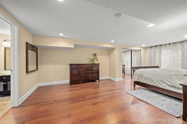 bedroom featuring hardwood / wood-style floors, ensuite bath, and a closet