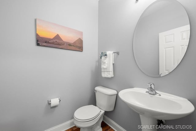 bathroom featuring sink, hardwood / wood-style floors, and toilet