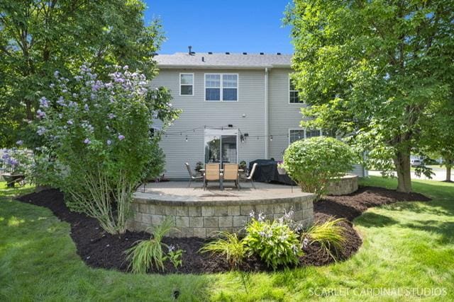 back of property featuring a yard and a patio area