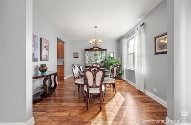 dining space with dark hardwood / wood-style flooring and a chandelier