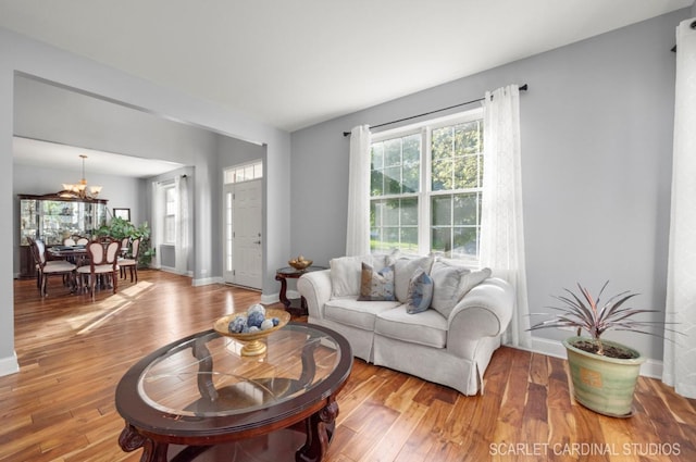 living room with an inviting chandelier and light wood-type flooring