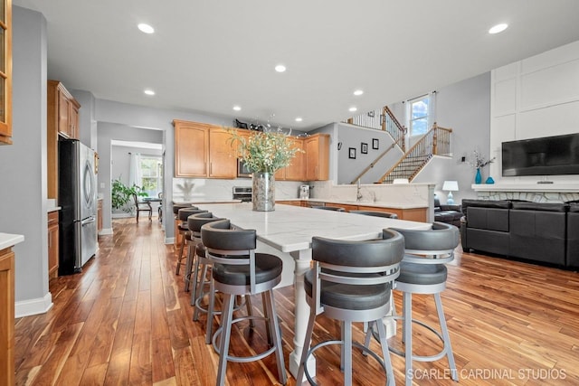 kitchen featuring light hardwood / wood-style flooring, a kitchen breakfast bar, a center island, and appliances with stainless steel finishes