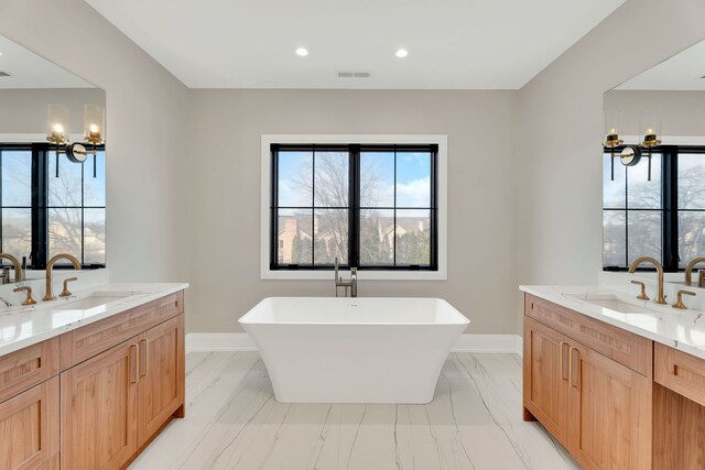 bathroom featuring vanity, a bathtub, a chandelier, and ornamental molding