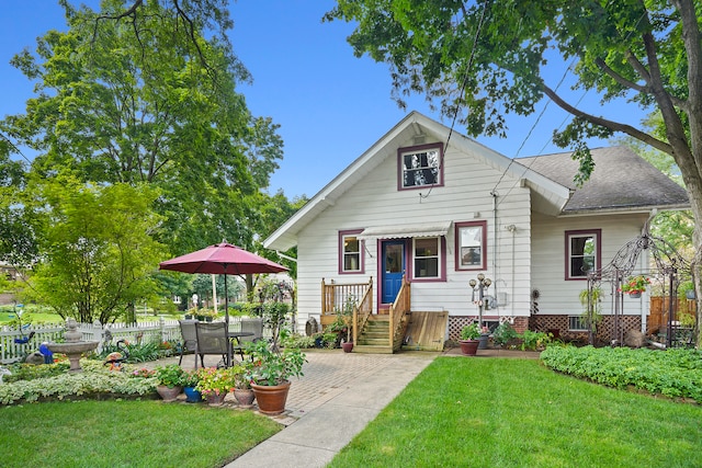 bungalow-style home with a front yard