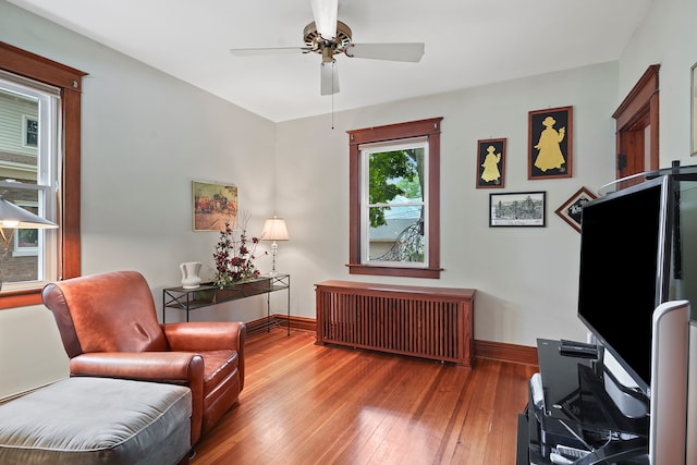 living area featuring radiator, ceiling fan, and hardwood / wood-style flooring