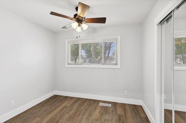 spare room featuring ceiling fan and dark hardwood / wood-style floors