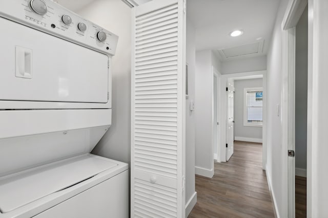 washroom with wood-type flooring and stacked washer and dryer