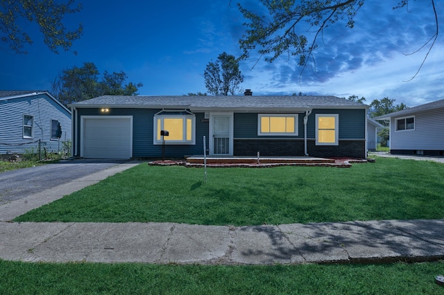 ranch-style home with a garage and a yard