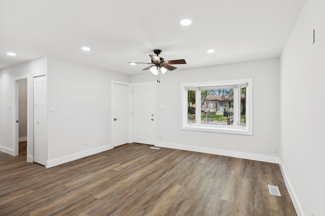 empty room with ceiling fan and dark hardwood / wood-style flooring