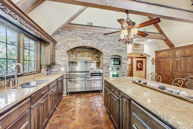 kitchen featuring vaulted ceiling with beams, light stone countertops, and sink