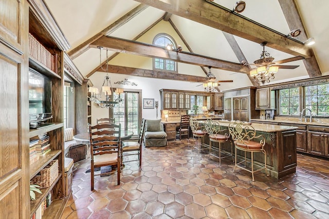 kitchen with a breakfast bar, high vaulted ceiling, plenty of natural light, and a kitchen island