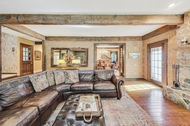 living room with beam ceiling, hardwood / wood-style floors, and a chandelier