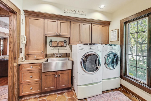 washroom featuring sink, cabinets, and washer and clothes dryer