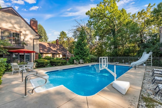 view of pool with a water slide and a patio area