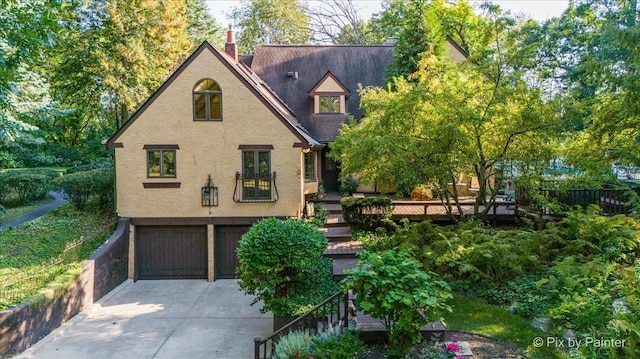 view of front of home with driveway, an attached garage, and stucco siding