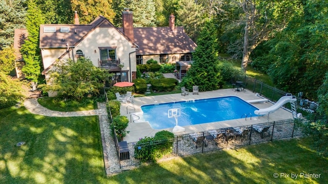 view of pool with a yard, a water slide, and a patio