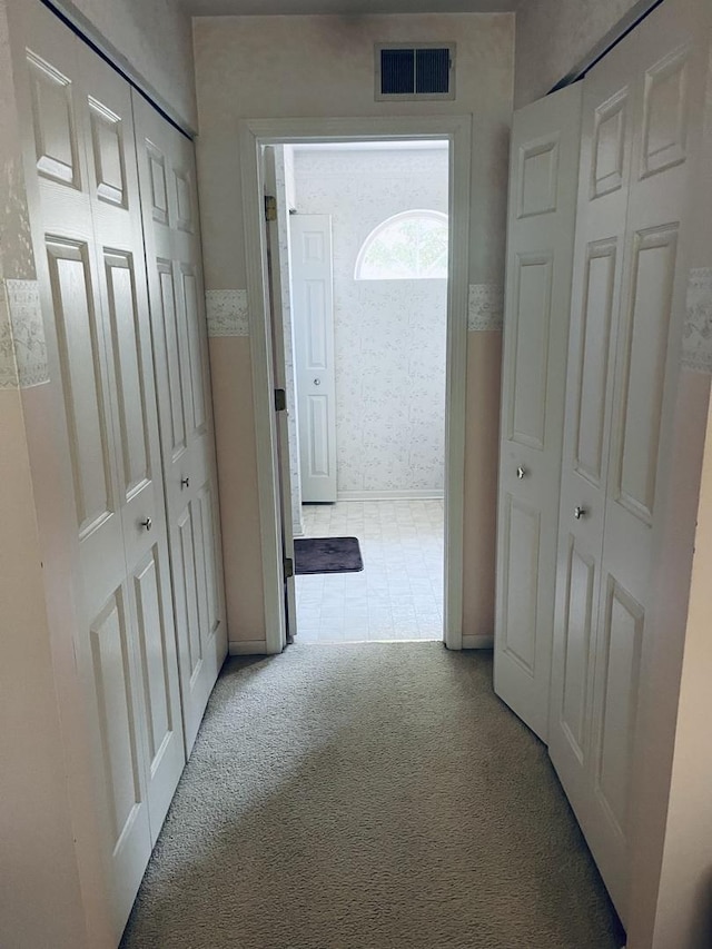 hallway featuring visible vents and carpet floors