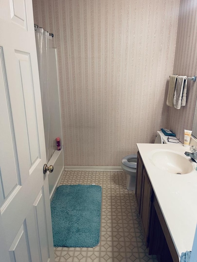 full bathroom featuring tile patterned floors, shower / bath combo, toilet, baseboards, and vanity