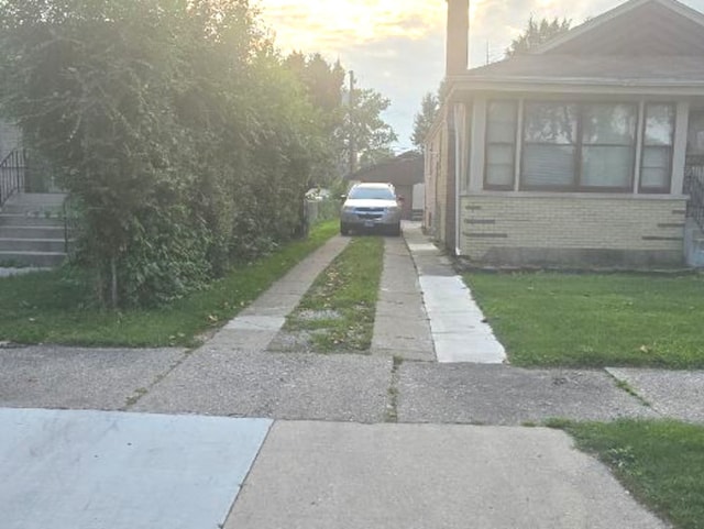 14420 S Lowe Ave, Riverdale, IL 60827 - view of side of property featuring driveway, brick siding, and a lawn