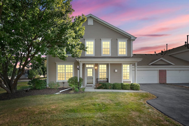 traditional home with a garage and a yard