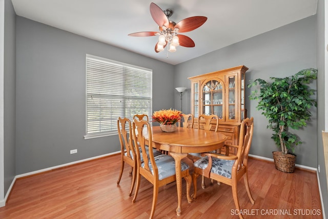 dining space featuring baseboards, ceiling fan, and light wood finished floors