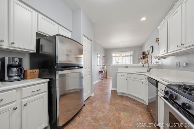 kitchen with a chandelier, a peninsula, stainless steel appliances, white cabinetry, and a sink